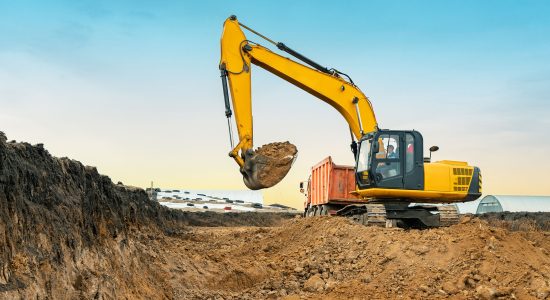 A large construction excavator of yellow color on the construction site in a quarry for quarrying. Industrial image.
